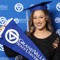 Upcoming graduate poses with GV flag at Gradfest